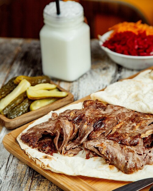 Vista superior de fatias de doner de carne colocadas entre pão sírio