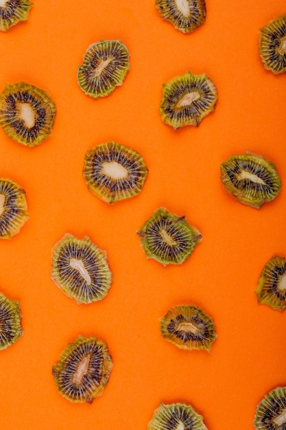 Vista superior de fatias de kiwi secas isoladas em fundo laranja