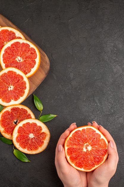 Foto grátis vista superior de fatias de toranja fresca no fundo escuro