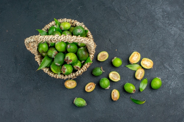 Vista superior de feijoas frescas em uma cesta em superfície escura