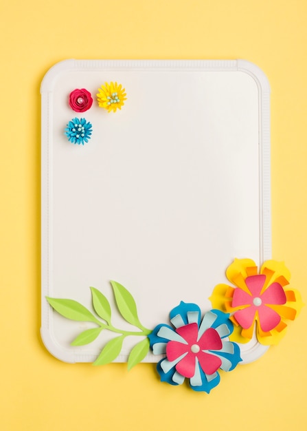 Vista superior de flores de papel para a primavera e quadro branco