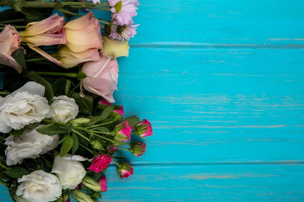 Foto grátis vista superior de flores em fundo azul com espaço de cópia