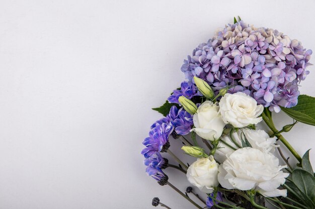 Vista superior de flores lindas e adoráveis, como rosas lilás, flores da margarida em um fundo branco com espaço de cópia