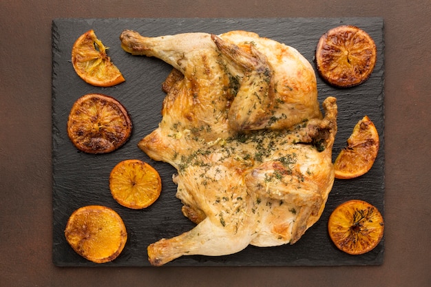 Vista superior de frango assado com fatias de laranja