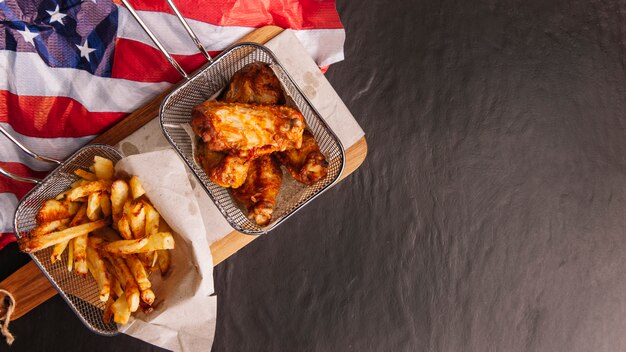 Vista superior de frango, batata frita e bandeira americana