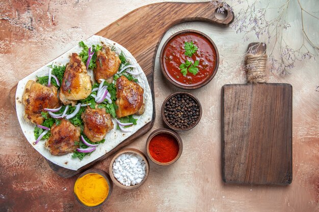 Vista superior de frango com frango com ervas de cebola em molho de lavash temperos coloridos