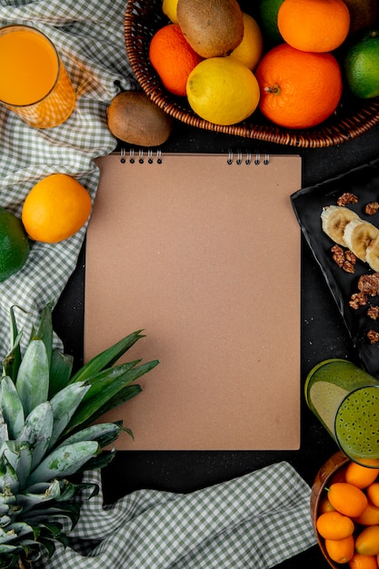 Foto grátis vista superior de frutas cítricas como abacaxi kiwi laranja na superfície do pano com espaço de cópia