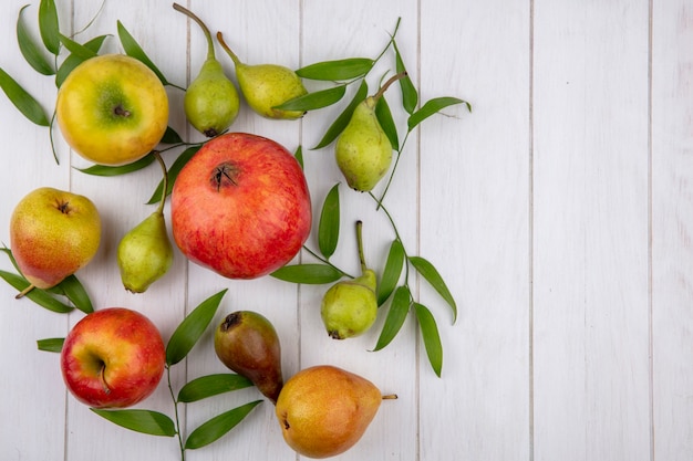 Vista superior de frutas como maçã de romã pêssego na superfície de madeira