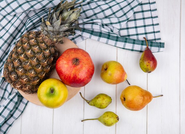 Vista superior de frutas na tábua no pano xadrez com pêssegos na superfície de madeira