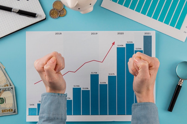 Vista superior de itens de negócios com gráfico de crescimento e mãos em punhos