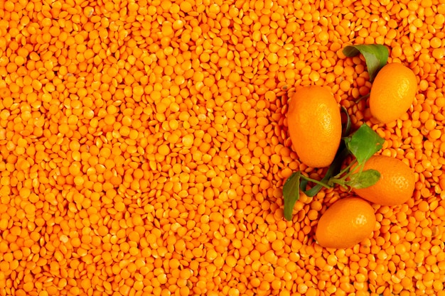 Vista superior de kumquat fresco em lentilhas vermelhas cruas