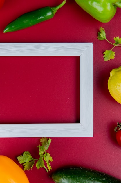 Foto grátis vista superior de legumes como coentro de pimenta pepino com limão e moldura na superfície do bordo com espaço de cópia