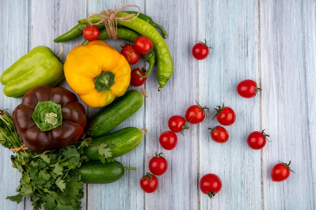 Vista superior de legumes como pepino de tomate coentro pimenta na superfície de madeira