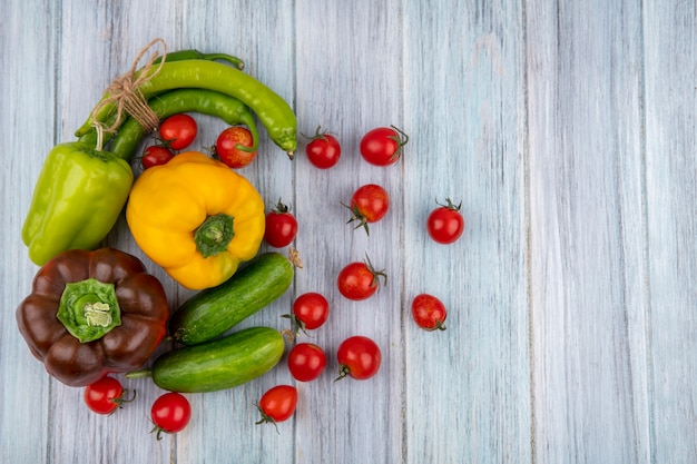 Vista superior de legumes como pimenta de pepino de tomate na superfície de madeira