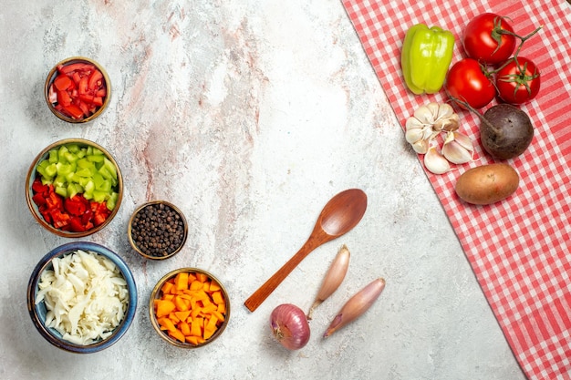 Foto grátis vista superior de legumes frescos com pimenta fatiada no espaço em branco