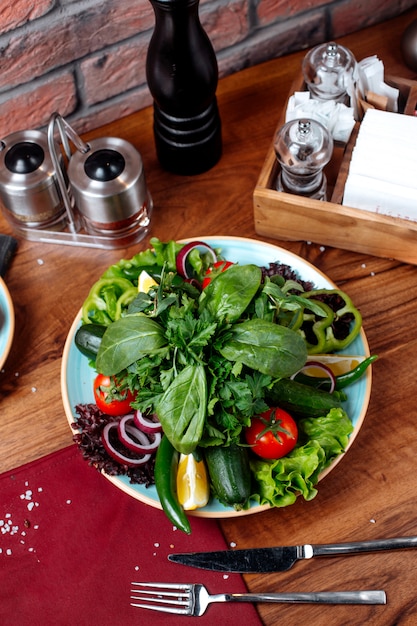Vista superior de legumes frescos tomate pepino cebola vermelha e ervas em uma mesa de madeira