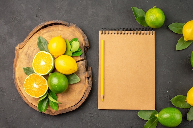 Vista superior de limões azedos frescos em frutas de mesa cinza-escuro e lima cítrica