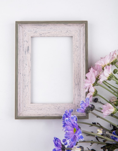 Vista superior de lindas flores margaridas em rosa pálido e violeta em um fundo branco com espaço de cópia