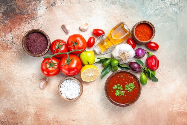 Vista superior de longe legumes especiarias molhos cebola alho limão tomate com pedicelos óleo de pimenta