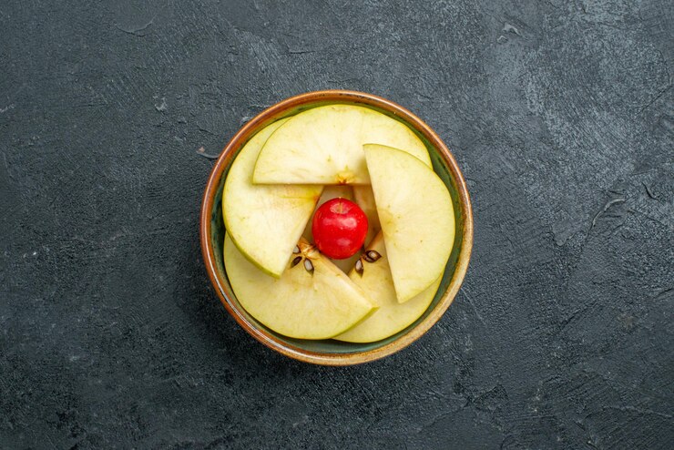 Foto grátis vista superior de maçãs frescas fatiadas dentro de um pequeno pote na superfície cinza frutas frescas maduras