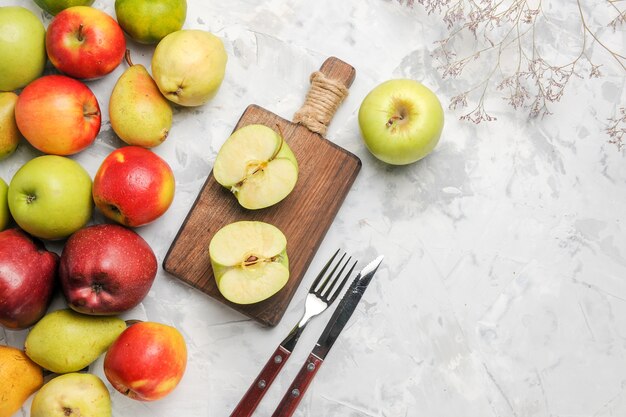 Vista superior de maçãs verdes com outras frutas em fundo branco claro