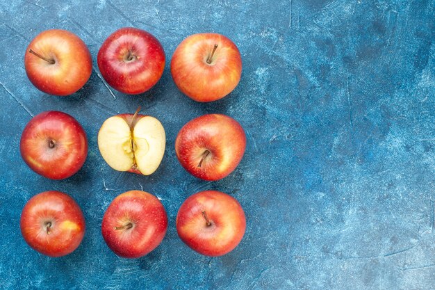 Vista superior de maçãs vermelhas frescas alinhadas na mesa azul