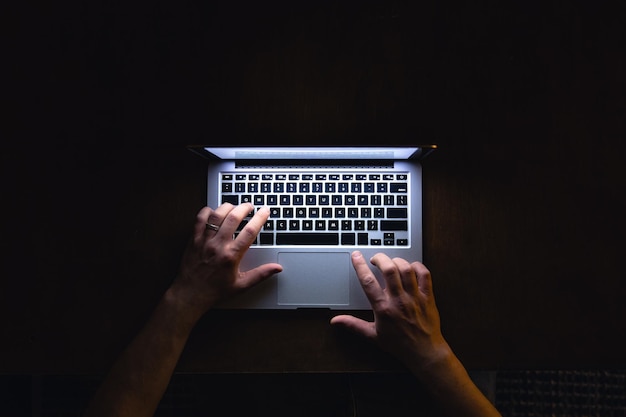 Foto grátis vista superior de mão de homem usando laptop no final da noite