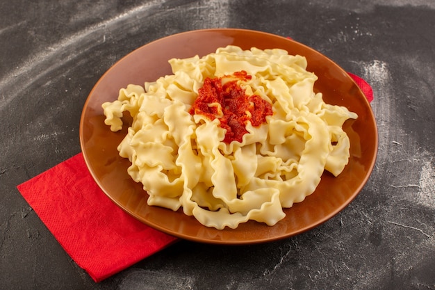 Vista superior de massa italiana cozida com molho de tomate no prato