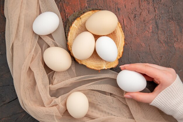Vista superior de ovos de galinha branca na mesa escura