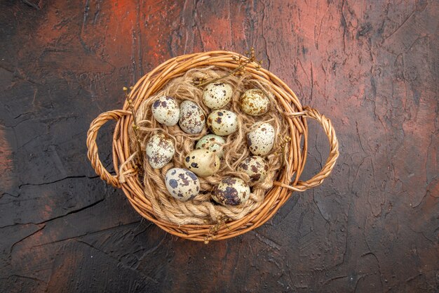 Vista superior de ovos frescos de granjas de aves orgânicas em uma cesta de tecido em um fundo marrom