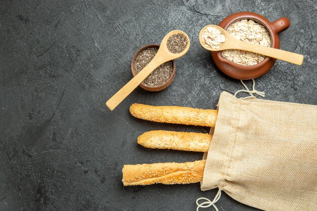 Vista superior de pães com cereais crus em uma superfície cinza