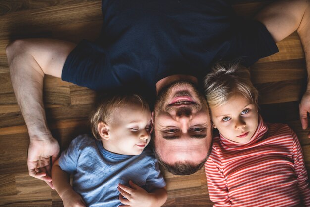 Vista superior de pai e filhos deitado no chão