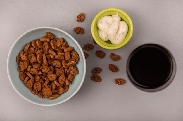 Vista superior de pequenas bolachas de centeio em uma tigela com um copo de coca-cola com molho