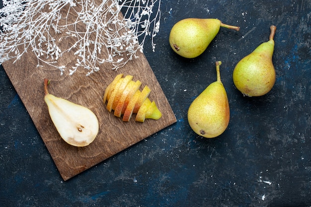 Foto grátis vista superior de peras frescas inteiras fatiadas e doces na mesa escura, frutas frescas e saudáveis.