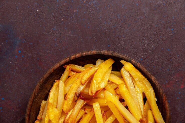 Foto grátis vista superior de perto batatas fritas saborosas batatas fritas dentro do prato na superfície escura comida refeição jantar prato ingredientes batata