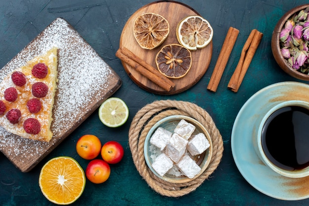 Vista superior de perto deliciosa fatia de bolo com chá de canela e frutas na mesa azul-escura torta bolo doce biscoito açúcar