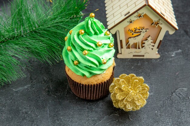 Vista superior de perto mini cupcake de árvore de natal com galho de árvore de natal em fundo escuro