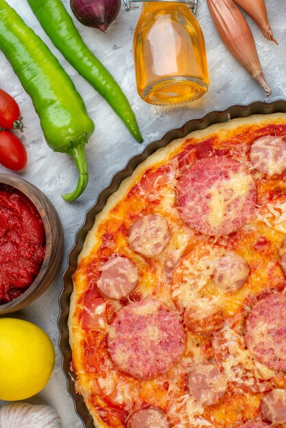 Foto grátis vista superior de perto saborosa pizza de linguiça com legumes frescos em branco