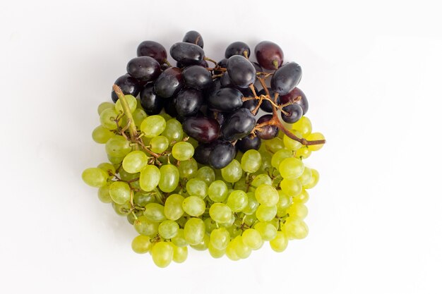 Vista superior de perto uvas frescas suculentas maduras e secas no fundo branco