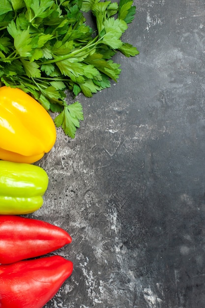 Foto grátis vista superior de pimentões frescos com verduras em fundo escuro