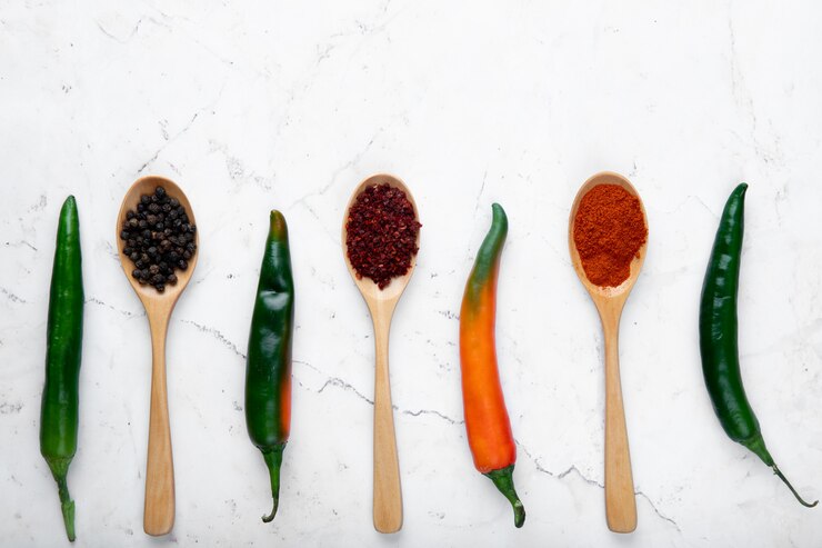 Foto grátis vista superior de pimentos e colheres cheias de especiarias em fundo branco
