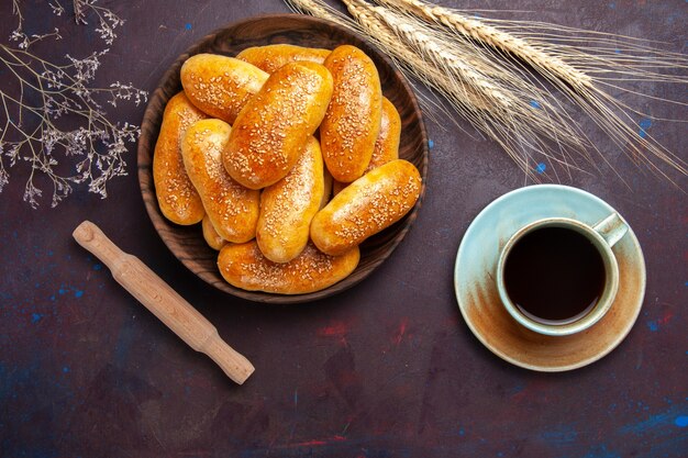 Vista superior de rissóis doces com uma xícara de chá no fundo escuro massa de pastelaria refeição comida rissóis chá