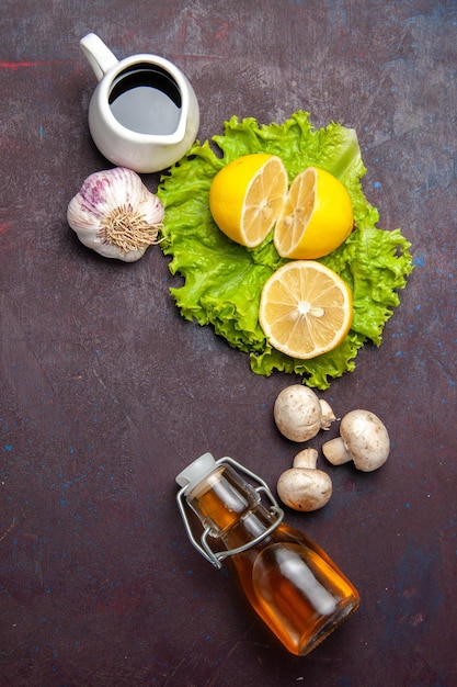 Vista superior de rodelas de limão frescas com salada verde no escuro