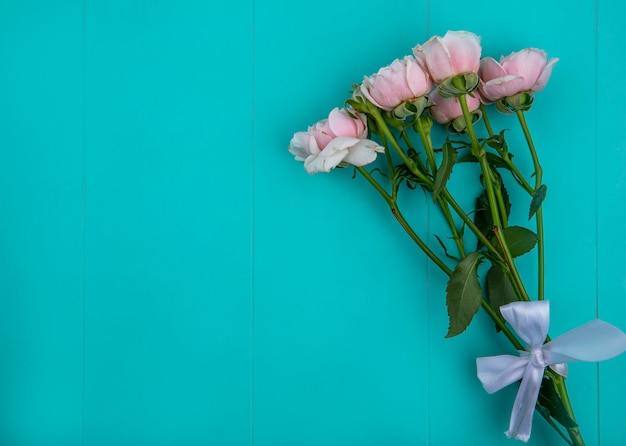 Vista superior de rosas rosa claras em uma superfície azul clara