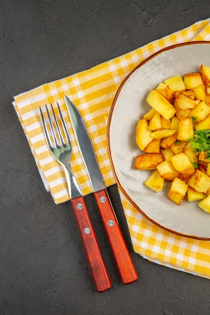 Vista superior de saborosas batatas fritas dentro do prato na superfície cinza-escura