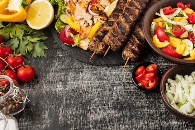 Vista superior de saborosos kebabs e outros pratos com ingredientes
