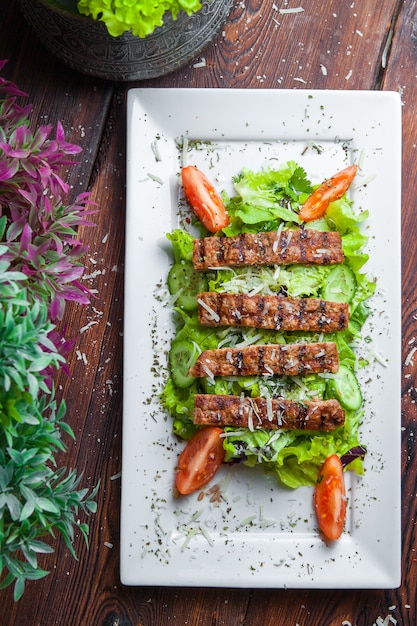 Vista superior de salada caesar com alface fresca, parmesão, croutons fritos e carne assada