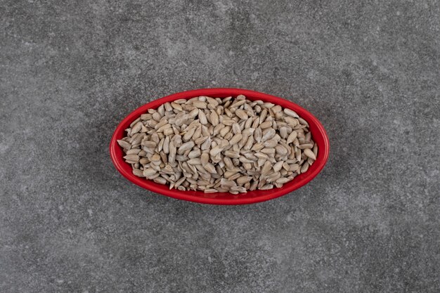 Vista superior de sementes de girassol frescas saudáveis em uma tigela vermelha.