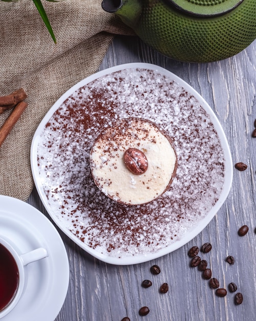 Vista superior de sobremesa de chocolate com creme e café em grão