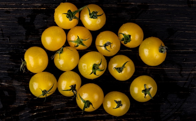 Vista superior de tomates amarelos na mesa de madeira